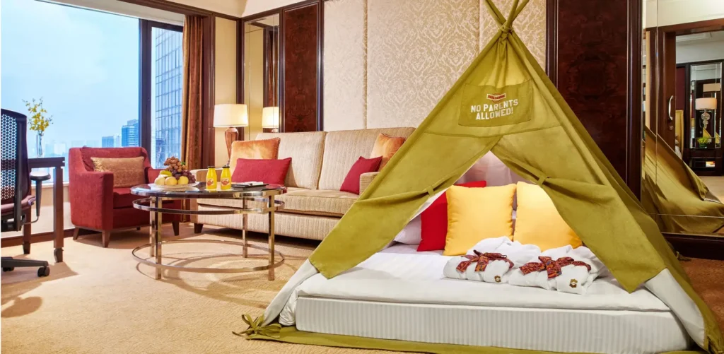 featuring a decorated kids' teepee tent, plush bedding, festive Christmas decorations, and spacious living area