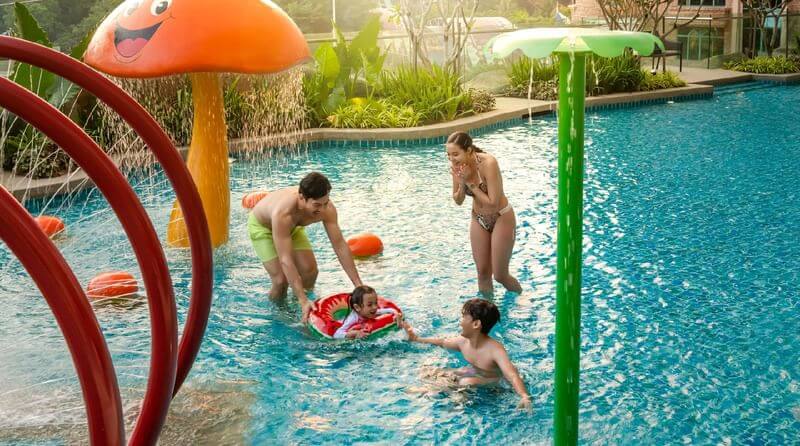 Alt text: Sunway Resort Hotel Waterventure water play area showing children enjoying splash buckets, sprinklers, and water slides with vibrant tropical landscaping