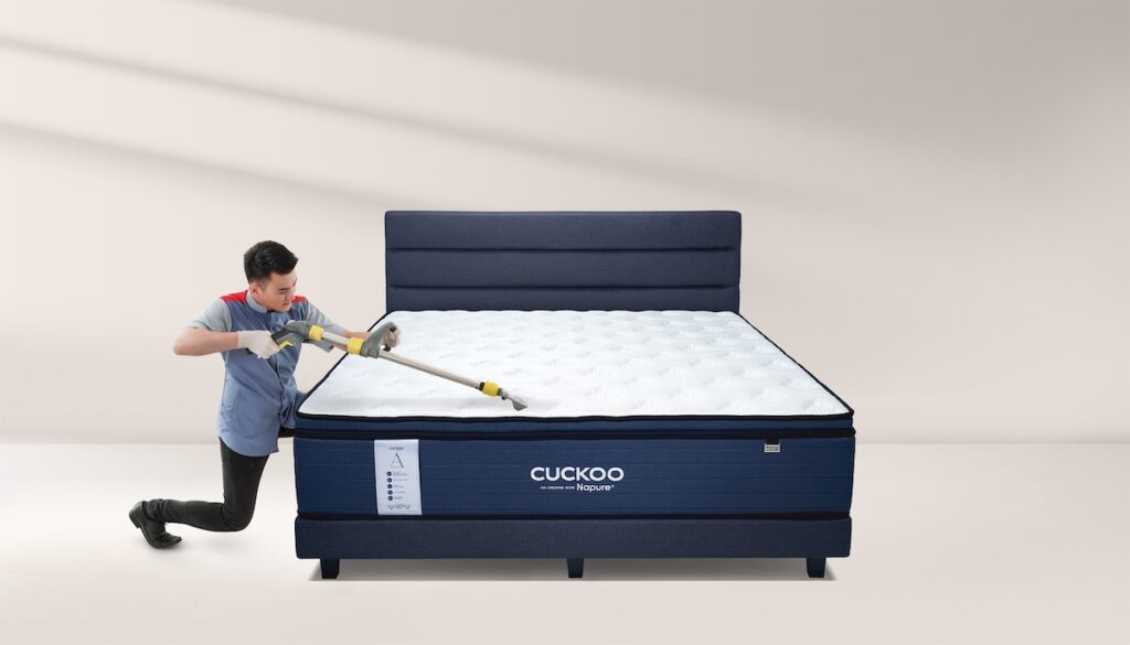 Professional Cuckoo Care Service technician deep cleaning an A-Series mattress to ensure a dust-mite-free sleeping environment.