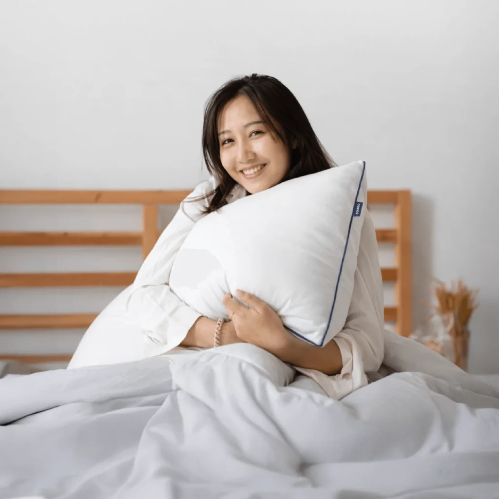Girl on bed hugging a Sonno pillow 